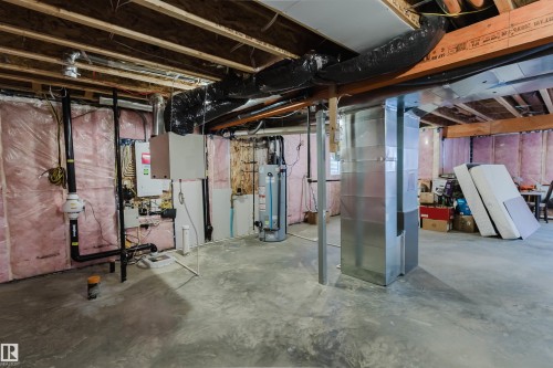 Unfinished basement with concrete flooring and exposed joists, featuring a hot water heater and HVAC ductwork - 3571 Keswick Boulevard, Edmonton, AB - Indoor Photo Showing Basement