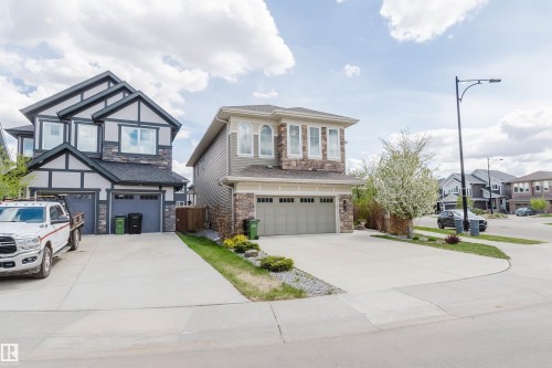 Contemporary two-story residence with a stone and siding exterior, featuring multiple gabled rooflines, an attached two-car garage, and a concrete driveway - 3571 Keswick Boulevard, Edmonton, AB - Outdoor With Facade