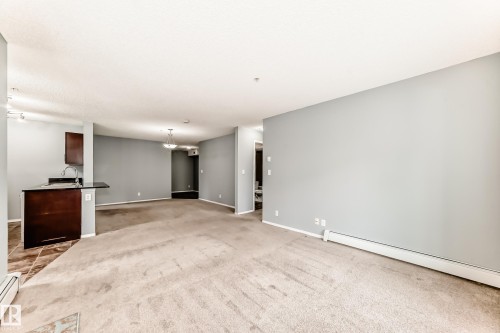 The interior features light gray walls and carpeted flooring throughout the main living areas - 101 530 Watt Boulevard, Edmonton, AB - Indoor Photo Showing Other Room