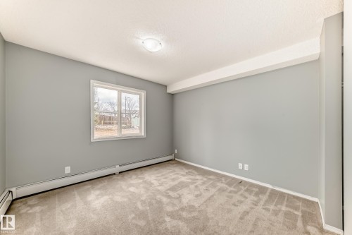 This room features neutral grey walls, light-colored carpeting, and a window providing natural light - 101 530 Watt Boulevard, Edmonton, AB - Indoor Photo Showing Other Room