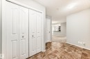 The entrance features durable tile flooring and bifold closet doors, with a clear sightline into the living area and kitchen - 101 530 Watt Boulevard, Edmonton, AB  - Indoor Photo Showing Other Room 