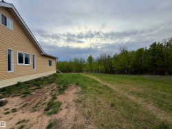 Exterior featuring horizontal siding, white trim, and a sloped roofline - 