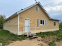 Exterior featuring horizontal vinyl siding, white trim, multiple window styles, and a gabled roof - 60016 Rr 41, Rural Barrhead County, AB  - Outdoor With Exterior 