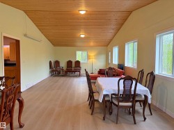 Expansive room featuring wood-finish flooring and a vaulted wood-paneled ceiling - 
