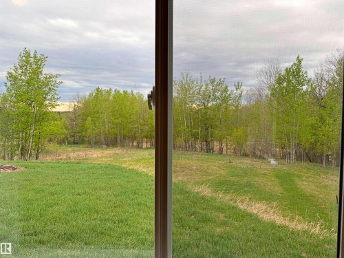 Expansive green space featuring a large lawn and mature deciduous trees - 60016 Rr 41, Rural Barrhead County, AB - Indoor Photo Showing Dining Room
