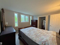 Spacious room featuring light gray walls, white trim, and wood-finish flooring - 