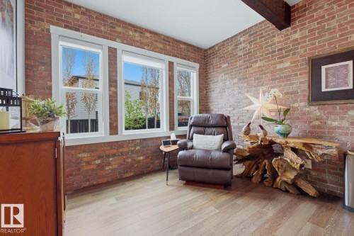 Exposed brick walls, wood-finish flooring, white-framed windows, and an exposed ceiling beam - 1359 Westerra Drive, Stony Plain, AB - Indoor