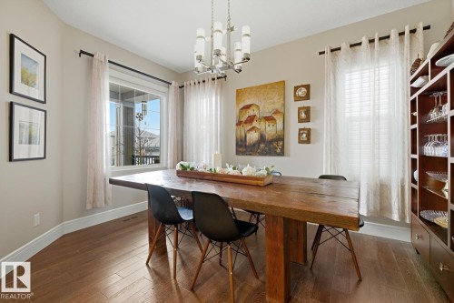 Spacious dining area featuring wood-finish flooring, neutral wall tones, and a contemporary chandelier - 1359 Westerra Drive, Stony Plain, AB - Indoor Photo Showing Dining Room