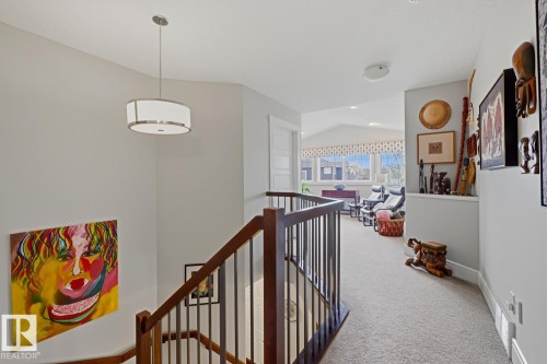 Upper level featuring a wood and metal railing, a drum pendant light fixture, and plush carpet flooring throughout - 1359 Westerra Drive, Stony Plain, AB - Indoor Photo Showing Other Room