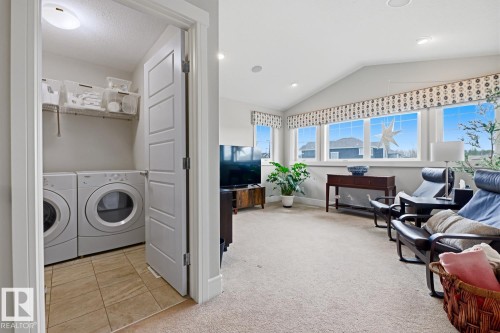 Dedicated laundry area featuring front-loading appliances and shelving - 1359 Westerra Drive, Stony Plain, AB - Indoor Photo Showing Laundry Room