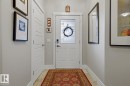 Front entry featuring a white paneled door with decorative glass, tiled flooring, and a mirrored accent wall - 1359 Westerra Drive, Stony Plain, AB  - Indoor Photo Showing Other Room 