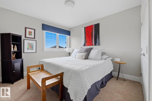 Carpeted bedroom featuring a double window, light gray walls, white trim, and a white paneled door - 1359 Westerra Drive, Stony Plain, AB - Indoor Photo Showing Bedroom