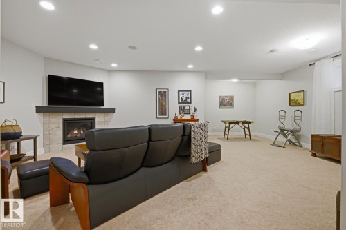 Spacious open-concept room featuring a fireplace with a stone tile surround and dark wood mantel - 1359 Westerra Drive, Stony Plain, AB - Indoor With Fireplace