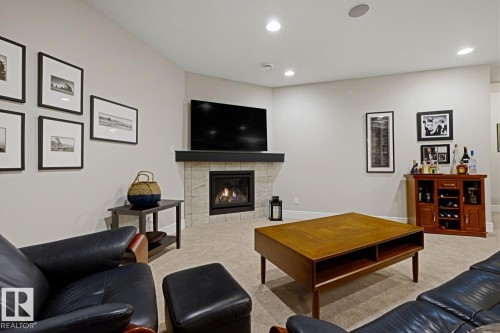 Corner gas fireplace with a tiled surround and dark mantel - 1359 Westerra Drive, Stony Plain, AB - Indoor Photo Showing Living Room With Fireplace