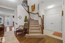 Grand entryway featuring a carpeted staircase with wood handrails, hardwood flooring, and a tiled entry foyer - 1359 Westerra Drive, Stony Plain, AB  - Indoor Photo Showing Other Room 