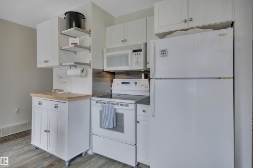 Kitchen featuring white cabinetry and appliances - 305 3 St, Rural Wetaskiwin County, AB - Indoor Photo Showing Kitchen