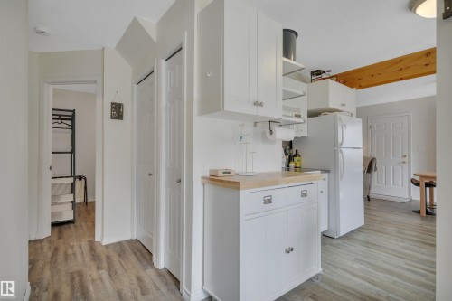 Compact kitchen space featuring white cabinetry, a wood-finish countertop, and wood-finish flooring - 305 3 St, Rural Wetaskiwin County, AB - Indoor