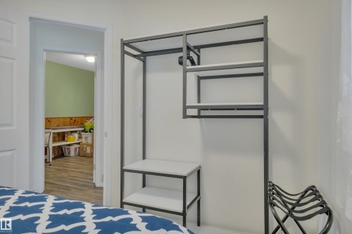 White-painted walls with wood-finish flooring visible through the doorway - 305 3 St, Rural Wetaskiwin County, AB - Indoor Photo Showing Bedroom
