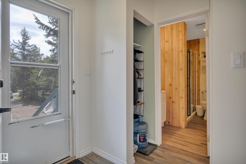 Entryway with wood-finish flooring, screen door, and coat hooks - 305 3 St, Rural Wetaskiwin County, AB - Indoor Photo Showing Other Room