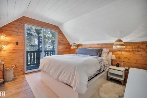 Sliding glass door opening to a balcony with a dark railing - 305 3 St, Rural Wetaskiwin County, AB - Indoor Photo Showing Bedroom