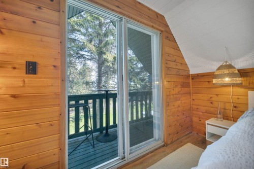 Sliding glass door opening to a private balcony with a dark green railing - 305 3 St, Rural Wetaskiwin County, AB - 