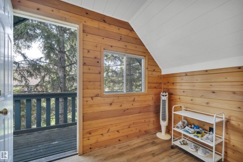 Room featuring horizontal wood paneling, wood-finish flooring, and a sloped white plank ceiling - 305 3 St, Rural Wetaskiwin County, AB - Indoor