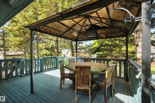 Deck area with a protective gazebo featuring a metal frame and a slatted roof - 305 3 St, Rural Wetaskiwin County, AB - Outdoor With Deck Patio Veranda With Exterior