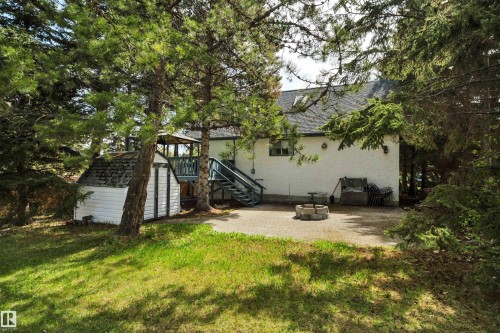 Rear exterior featuring a white stucco finish, a dark shingle roof, and a visible window opening - 305 3 St, Rural Wetaskiwin County, AB - Outdoor