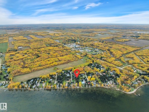 Aerial perspective showcasing a residential area bordered by a body of water and expansive golden autumn foliage - 305 3 St, Rural Wetaskiwin County, AB - Outdoor With Body Of Water With View