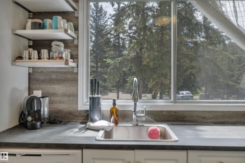 Kitchen workspace with a stainless steel sink, chrome faucet, and dark countertop - 305 3 St, Rural Wetaskiwin County, AB - Indoor Photo Showing Kitchen
