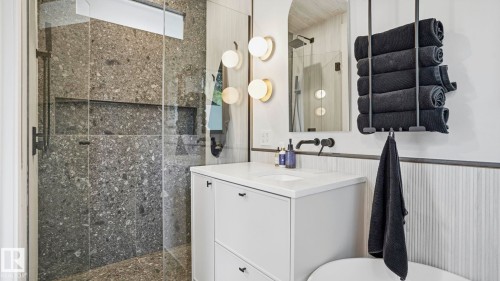 Spacious shower with large format speckled tile, integrated niche shelving, and clear glass enclosure - 6412 Ada Boulevard, Edmonton, AB - Indoor Photo Showing Bathroom