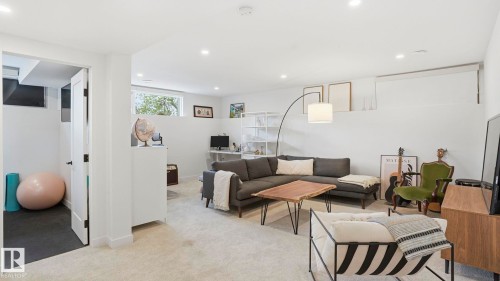 Finished lower level with recessed lighting, light-toned carpet flooring, and a dedicated room with dark flooring - 6412 Ada Boulevard, Edmonton, AB - Indoor Photo Showing Living Room