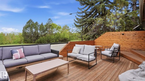 Multi-level wood deck featuring a slatted wood privacy wall, wood plank flooring, and integrated exterior lighting - 6412 Ada Boulevard, Edmonton, AB - Outdoor With Deck Patio Veranda