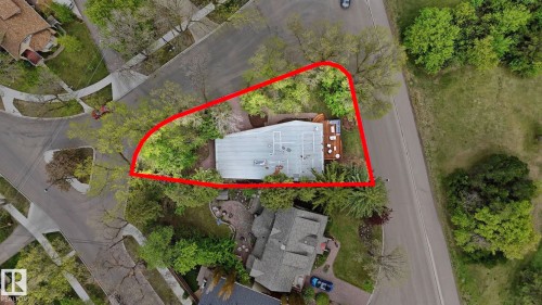 Aerial perspective showcasing a property featuring mature perimeter trees, a light-colored roof, and an exterior deck - 6412 Ada Boulevard, Edmonton, AB - Outdoor With View