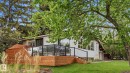 Expansive wooden deck featuring glass panel railings and black metal handrails - 6412 Ada Boulevard, Edmonton, AB  - Outdoor 