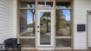 Modern entry featuring a full-light door with sidelights, transom windows, textured glass accents, and white horizontal siding - 6412 Ada Boulevard, Edmonton, AB  - Outdoor With Exterior 