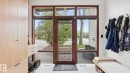 Entryway featuring a wood-frame glass panel door, complementary side windows, light-tone wood-finish built-in cabinetry, and white flooring with a herringbone pattern - 6412 Ada Boulevard, Edmonton, AB  - Indoor Photo Showing Other Room 