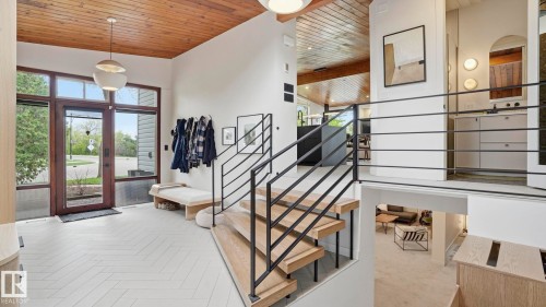 Entryway featuring a wood-paneled ceiling, a modern pendant light, and chevron-patterned wood-finish flooring - 6412 Ada Boulevard, Edmonton, AB - Indoor Photo Showing Other Room