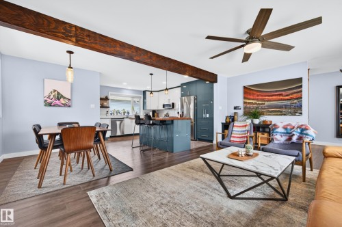 Open-concept living space featuring wood-finish flooring, a prominent wooden beam, and a ceiling fan with integrated lighting - 6707 92B Avenue, Edmonton, AB - Indoor Photo Showing Living Room