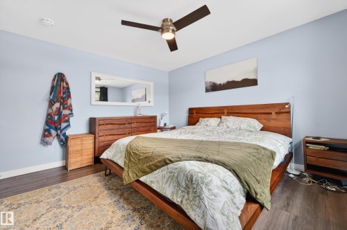 Interior room featuring wood-finish flooring, a ceiling fan with integrated lighting, and light blue wall tones - 6707 92B Avenue, Edmonton, AB - Indoor Photo Showing Bedroom