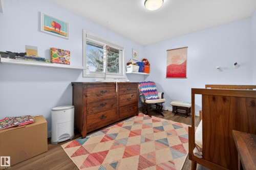 Room featuring wood-finish flooring, light blue walls, and a recessed window with a white frame - 6707 92B Avenue, Edmonton, AB - Indoor