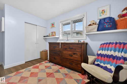 Room featuring wood-finish flooring, light blue wall paint, and white trim - 6707 92B Avenue, Edmonton, AB - Indoor Photo Showing Bedroom