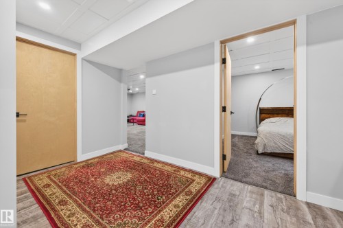 Light wood-finish doors with matte black hardware, light gray walls, white trim, and recessed lighting - 6707 92B Avenue, Edmonton, AB - Indoor Photo Showing Other Room