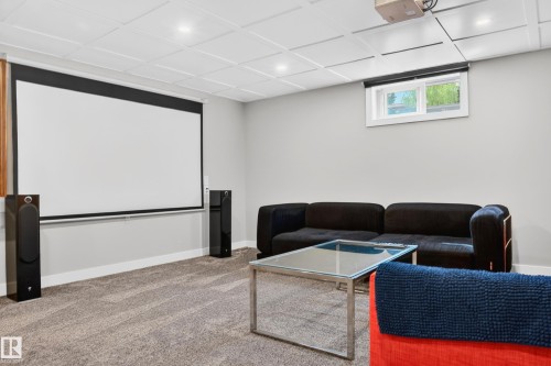 Dedicated media room featuring a large projector screen, recessed lighting, and a drop ceiling - 6707 92B Avenue, Edmonton, AB - Indoor