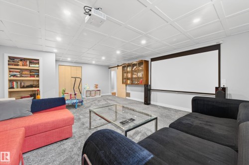 Entertainment space featuring a large projection screen and a ceiling-mounted projector - 6707 92B Avenue, Edmonton, AB - Indoor
