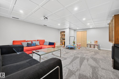 Spacious finished room featuring textured carpeting, recessed lighting, and a coffered ceiling - 6707 92B Avenue, Edmonton, AB - Indoor