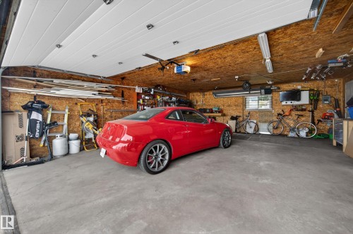 Attached two-car garage featuring a concrete floor and wood paneling on walls and ceiling - 6707 92B Avenue, Edmonton, AB - Indoor Photo Showing Garage