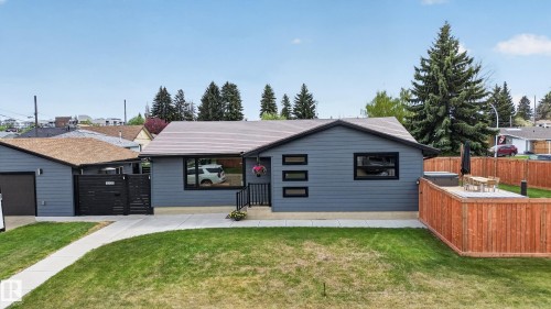 Contemporary ranch-style home featuring gray horizontal siding and contrasting black trim windows - 6707 92B Avenue, Edmonton, AB - Outdoor