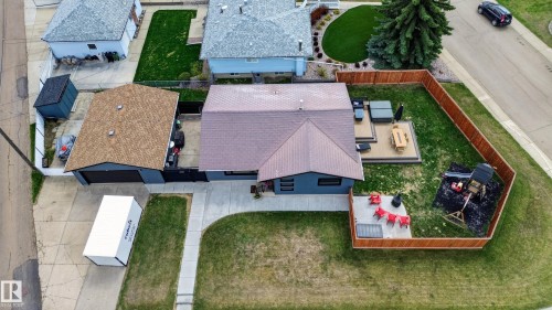 Rear yard featuring a wood privacy fence, elevated composite deck, and a concrete patio - 6707 92B Avenue, Edmonton, AB - Outdoor