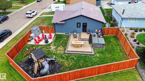 Expansive backyard featuring a multi-level deck, privacy fencing, a manicured lawn, and a designated play area - 6707 92B Avenue, Edmonton, AB - Outdoor With Deck Patio Veranda